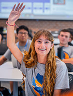 Student in class with hand raised